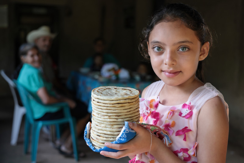 Dilcia Muñoz lleva las tortillas a la mesa para el desayuno de su familia en Lempira, Honduras. Su hogar logró superar el hambre gracias al cultivo sostenible de alimentos. Foto por Silverlight/Oscar Leiva para CRS.  