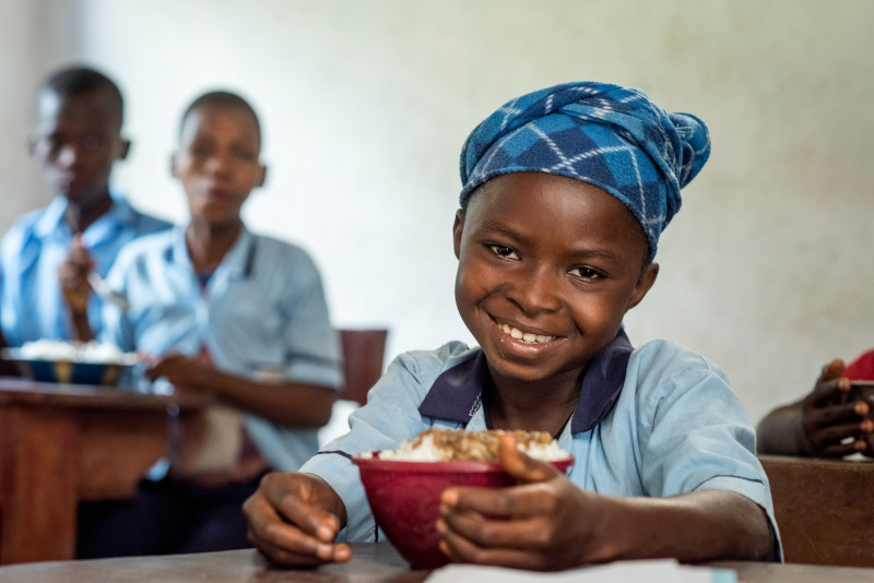 Una estudiante en Sierra Leona recibe todos los días un nutritivo almuerzo en la escuela. Estos alimentos le permiten mantenerse lejos del hambre y la desnutrición, que impactan a niños de su comunidad. Foto por Michael Stulman/CRS. 